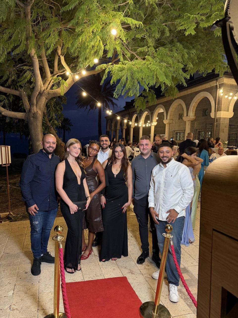 אורחים מצטלמים על השטיח האדום בעמדת הצילום של Snap Box באירוע גן בערב